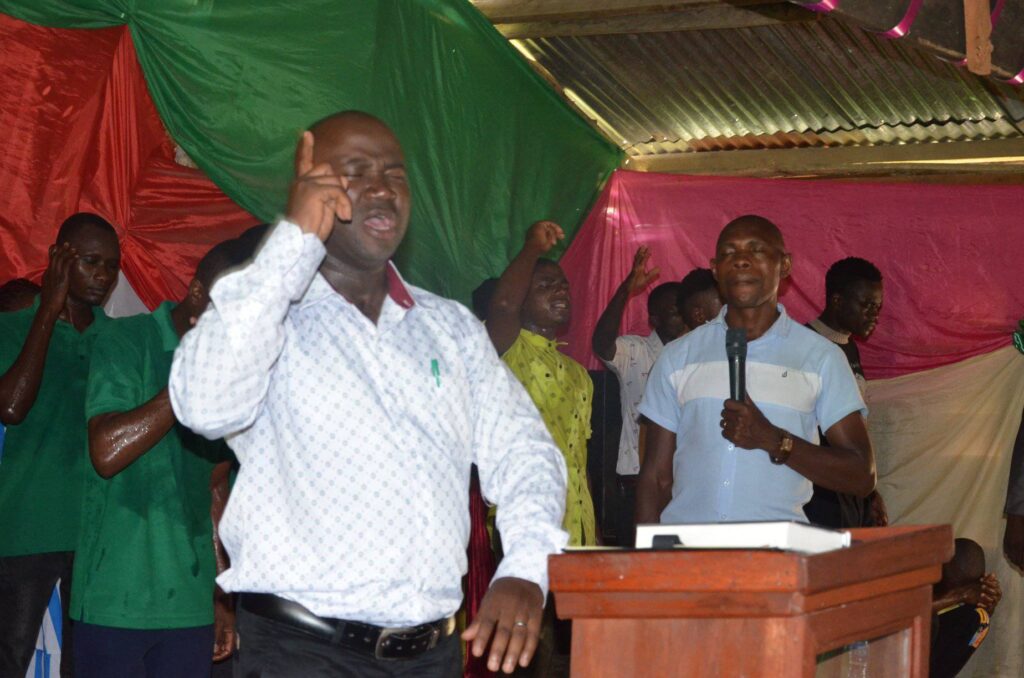 Pr. Benard praying in a church service